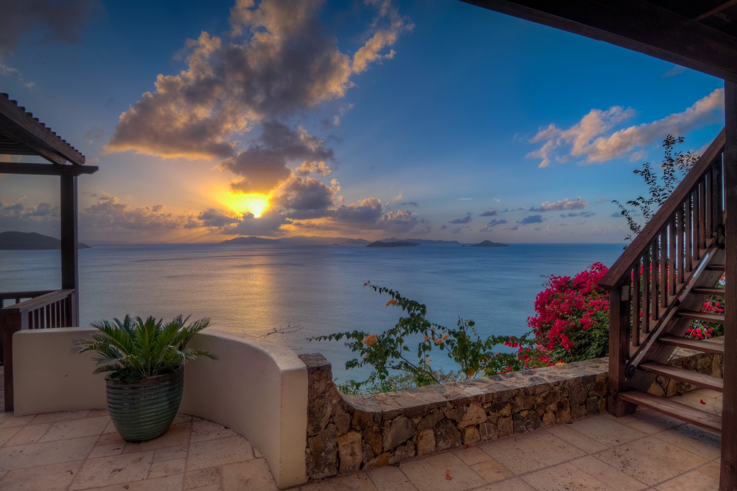 Sunset over the water, seen from the terrace with bougainvillea in the foreground