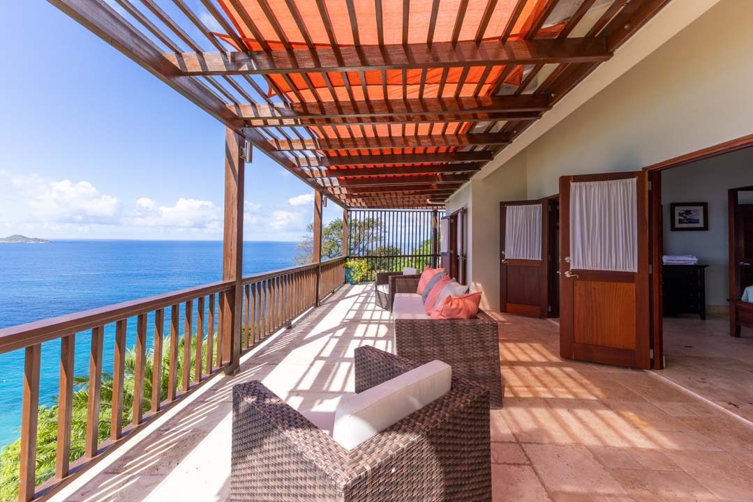 Covered terrace with wicker seating overlooking the ocean
